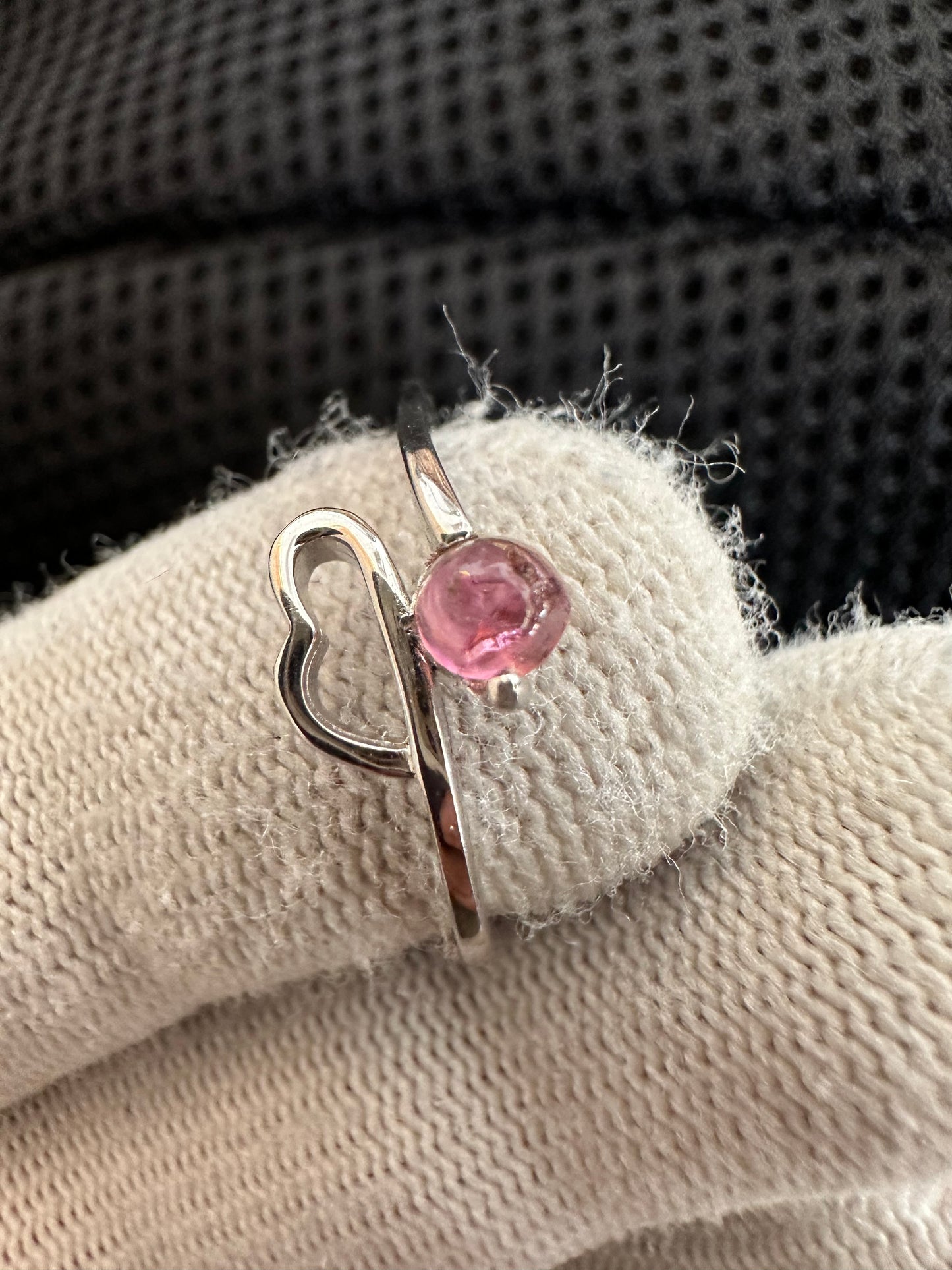 Silver ring with an oval-cut pink tourmaline gemstone,featuring a polished band with intricate detailing