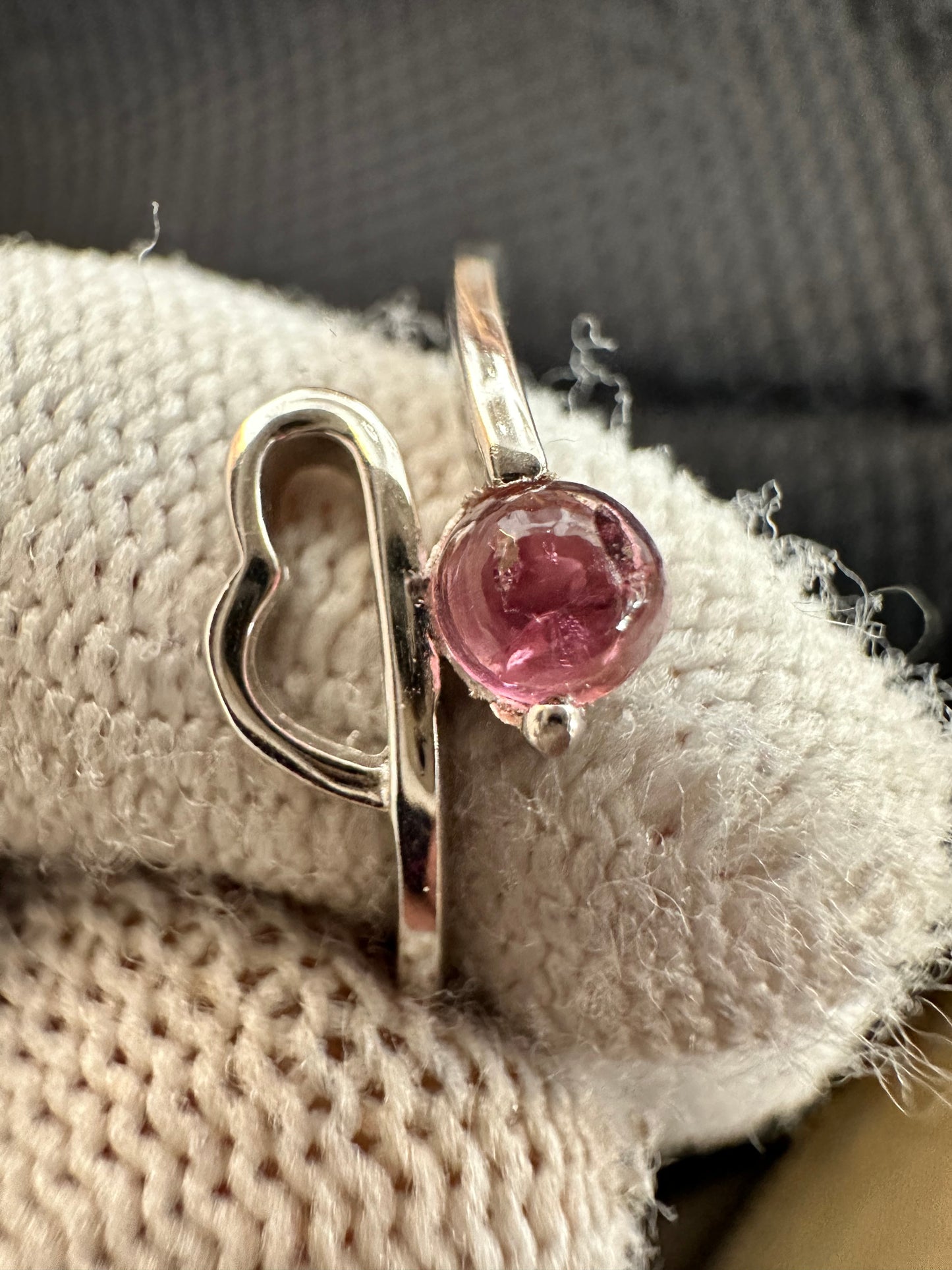 Silver ring with an oval-cut pink tourmaline gemstone,featuring a polished band with intricate detailing