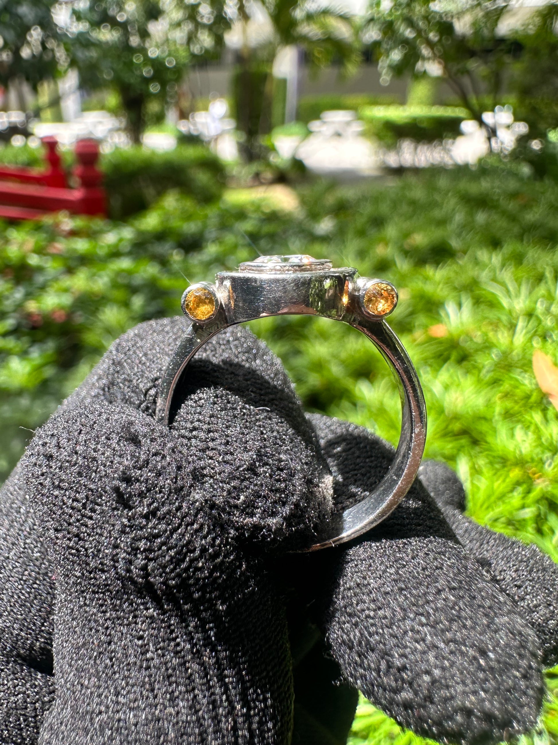 Elegant D Color Moissanite Ring with GRA Certificate, featuring a brilliant center stone complemented by vibrant yellow sapphire accent gems, set in polished 925 sterling silver – a luxurious and ethically sourced diamond alternative.