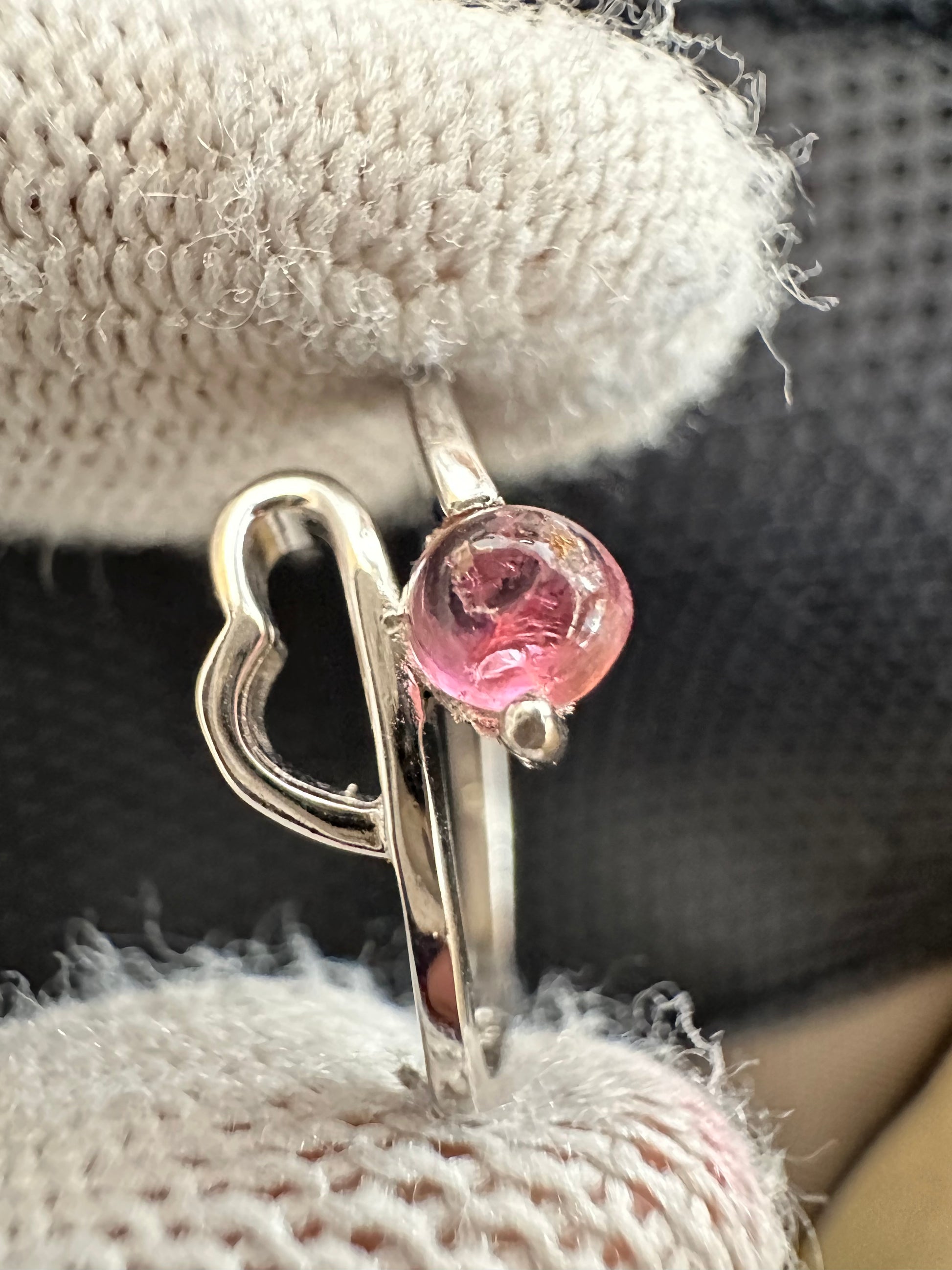 Silver ring with an oval-cut pink tourmaline gemstone,featuring a polished band with intricate detailing