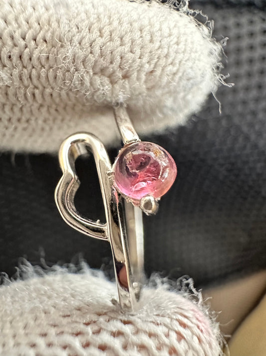 Silver ring with an oval-cut pink tourmaline gemstone,featuring a polished band with intricate detailing