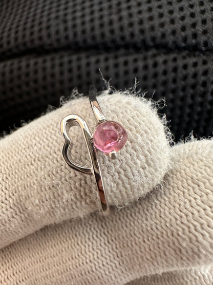 Silver ring with an oval-cut pink tourmaline gemstone,featuring a polished band with intricate detailing